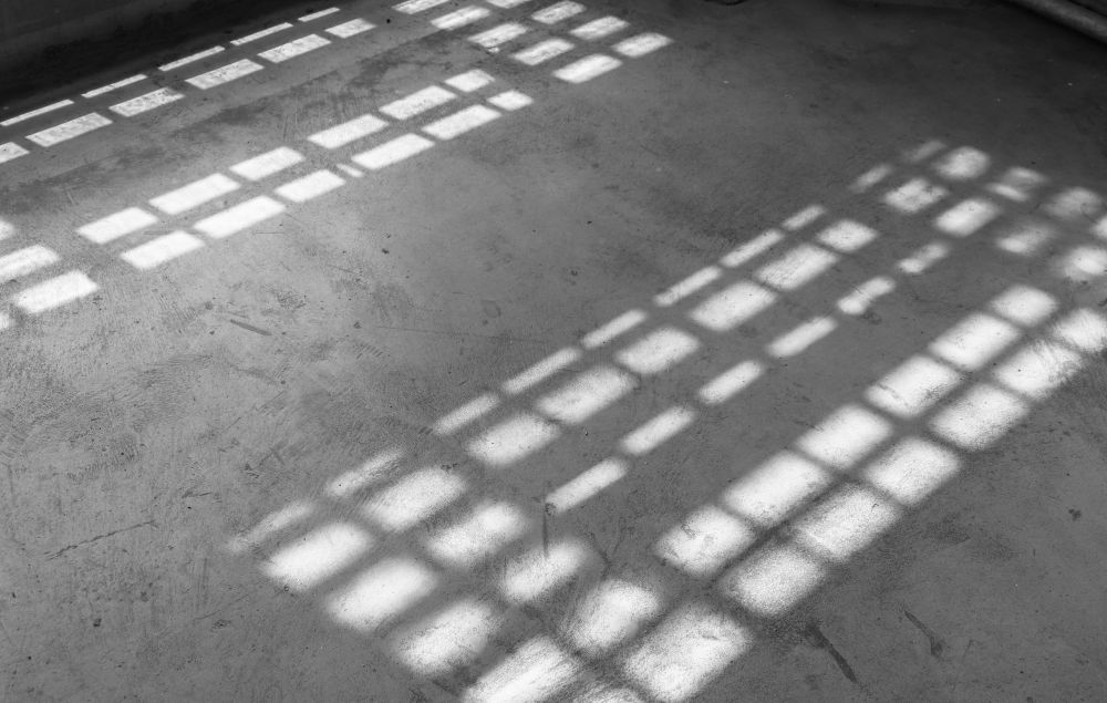 a black and white photo of a room with a light on the ground