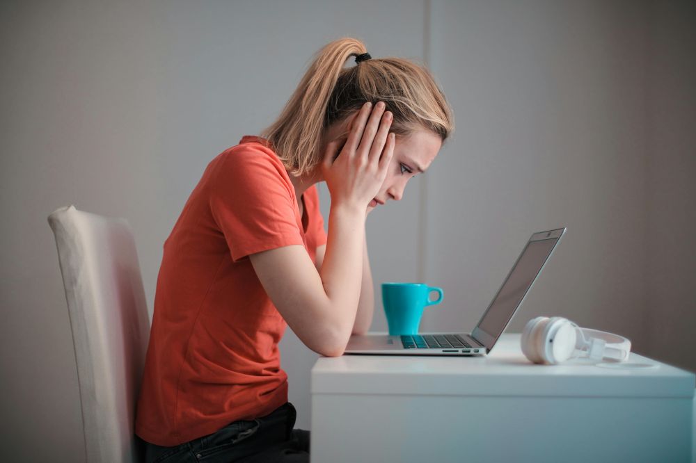 a person sitting at a table with a laptop