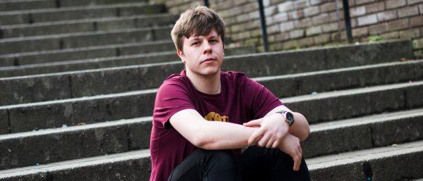 Young man sitting on some steps outside.