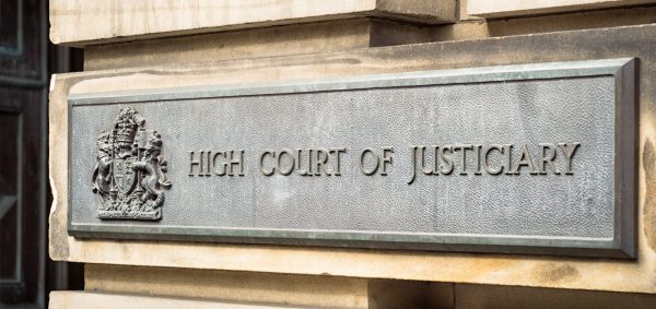 A majestic building with the words "High Court of Justice" engraved on the facade.