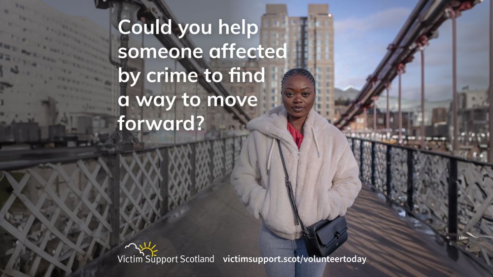 Person in a white jacket standing on a bridge with text about crime victim support and a website URL.
